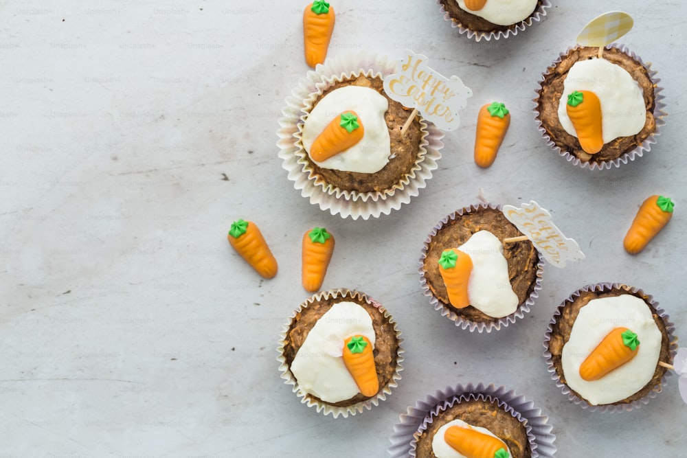 carrot cupcakes with frosting and carrots on top