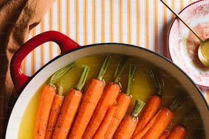 a pot filled with carrots sitting on top of a table