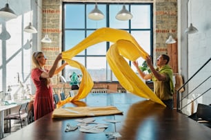 a man and a woman are working on a sculpture