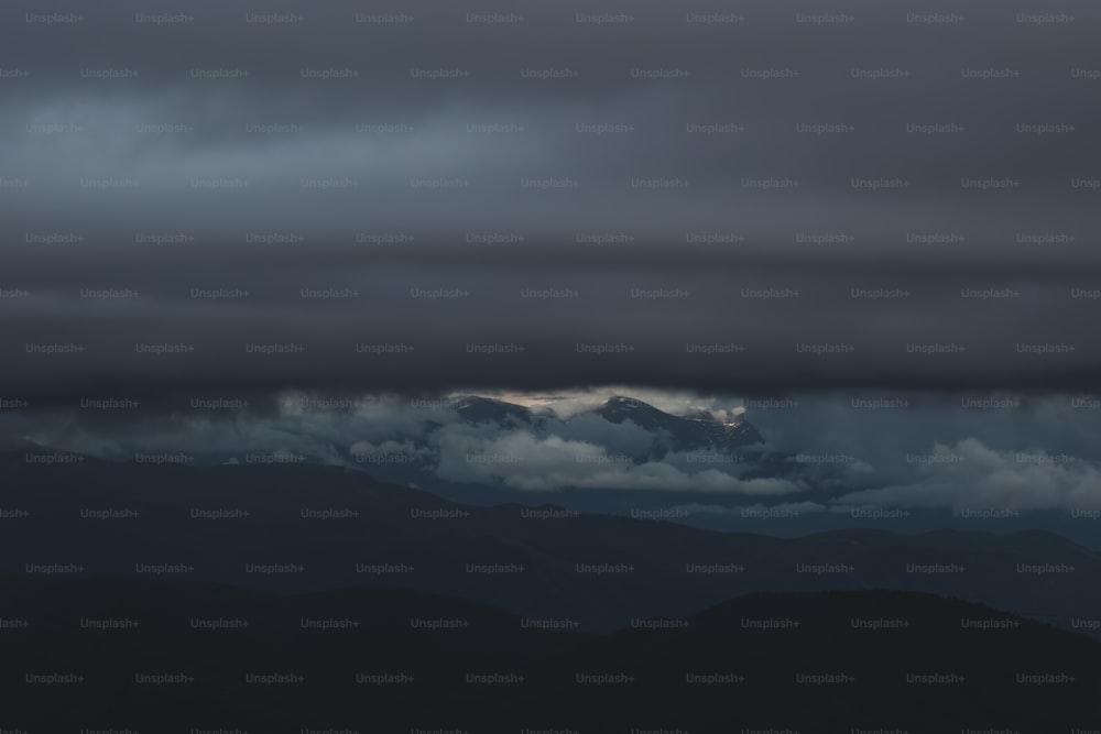 uma vista de uma cordilheira sob um céu nublado