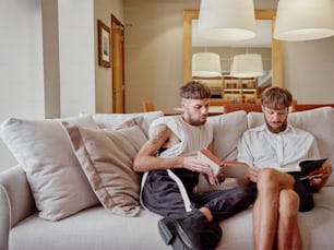 a couple of men sitting on top of a couch