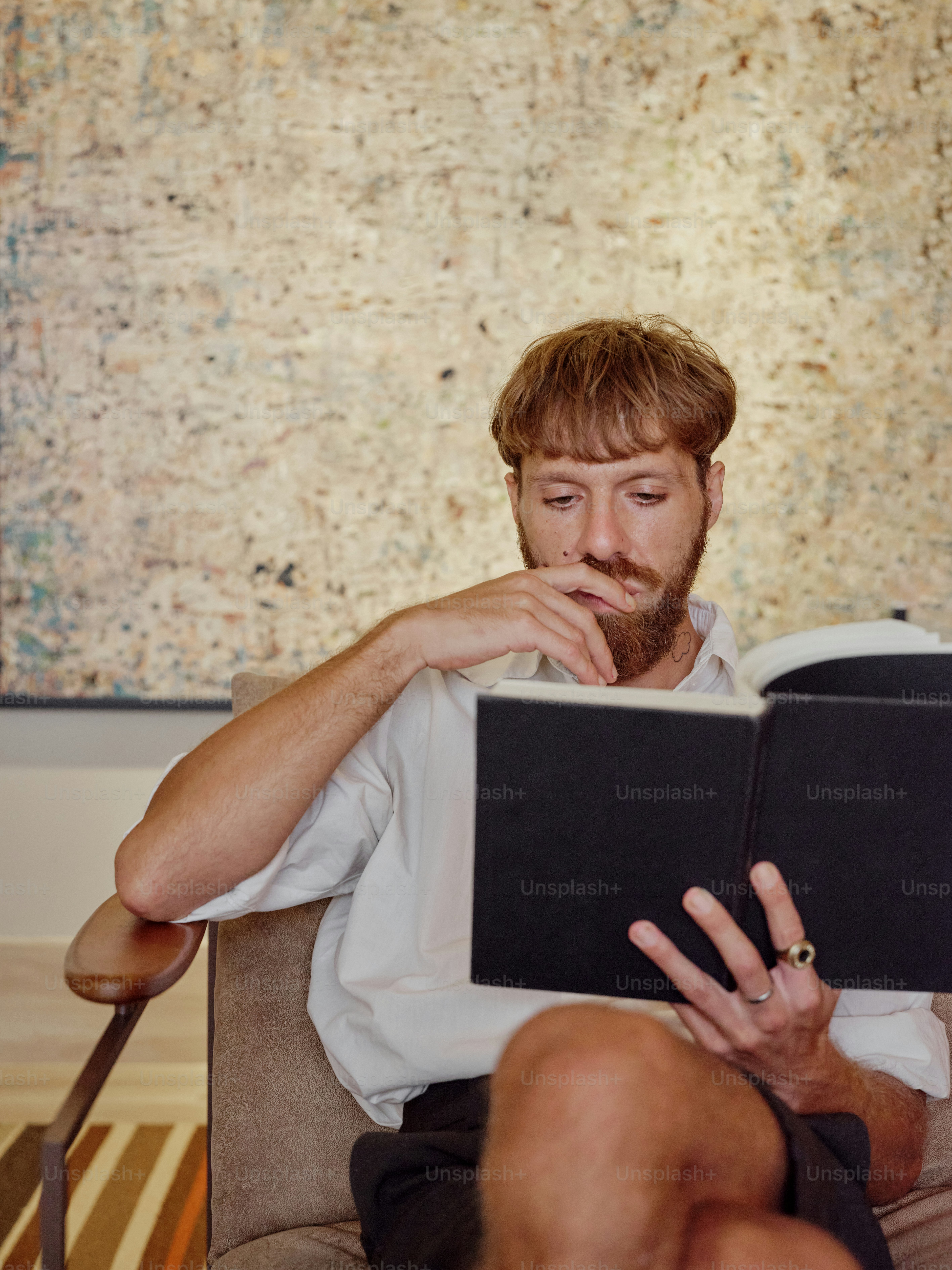 a man sitting in a chair reading a book