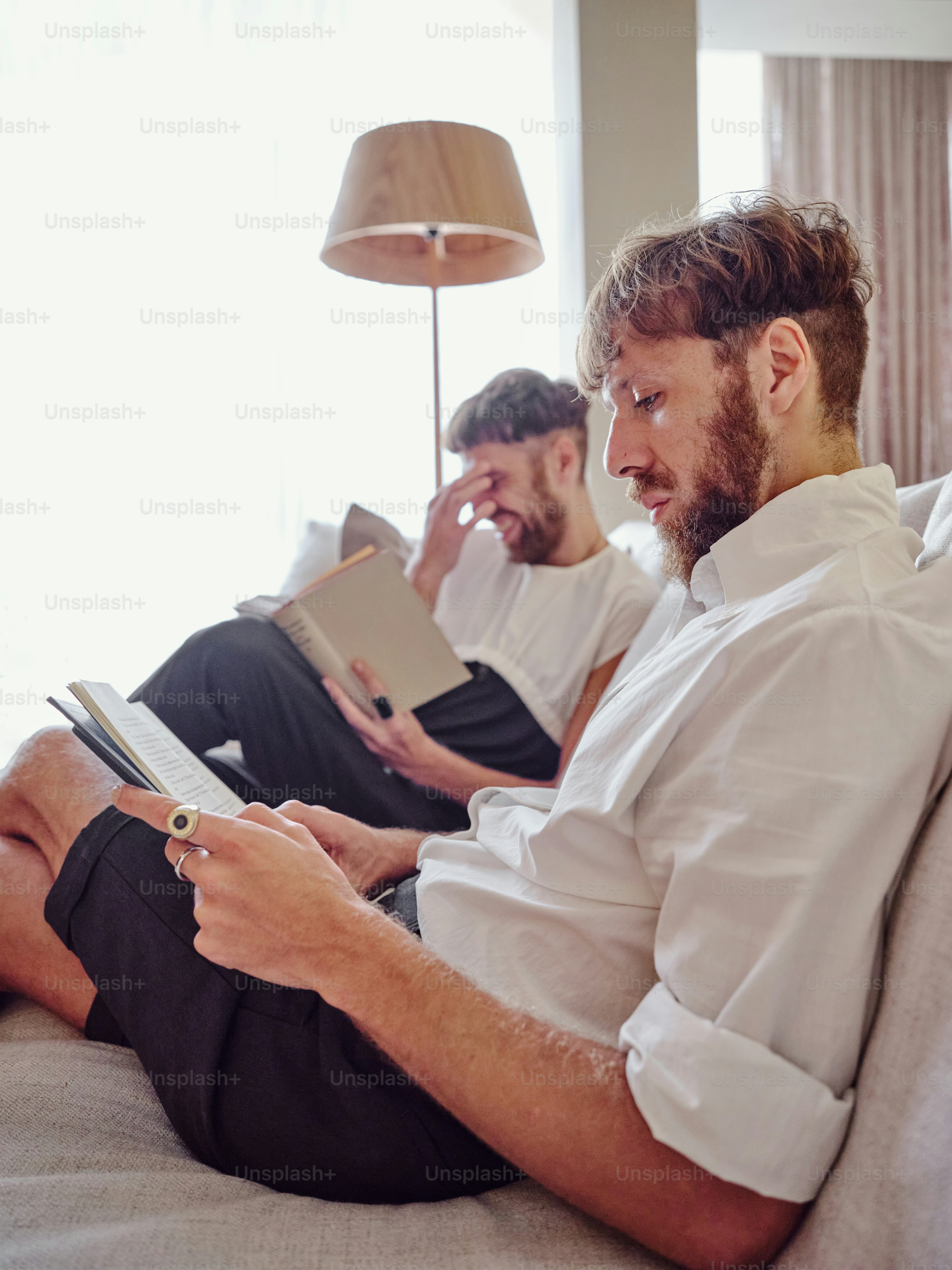 um casal de homens sentados em cima de um sofá