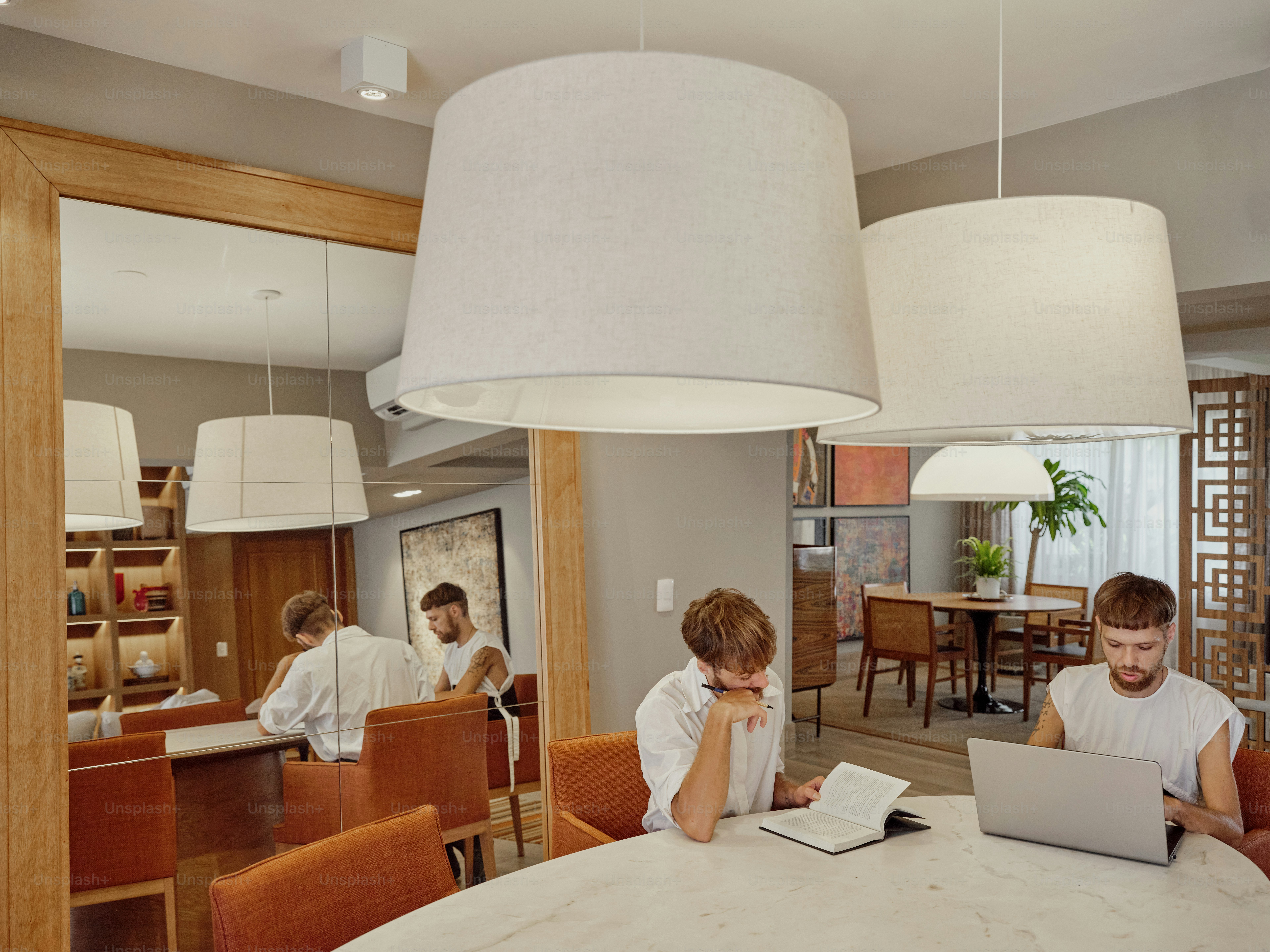 a couple of people sitting at a table with a laptop