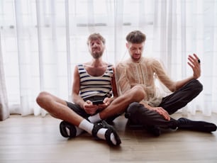 two men sitting on the floor with their legs crossed