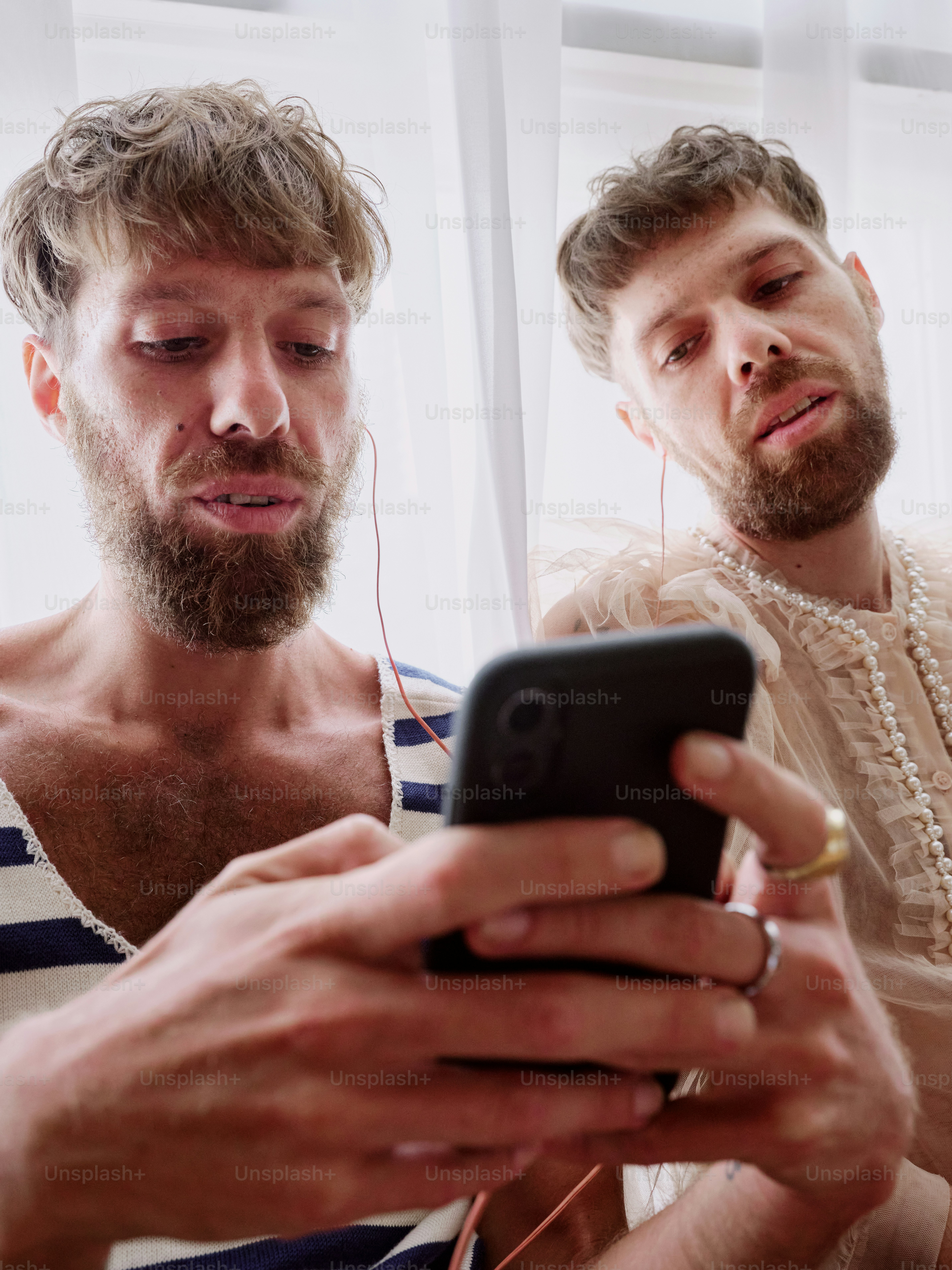 two men are looking at a cell phone