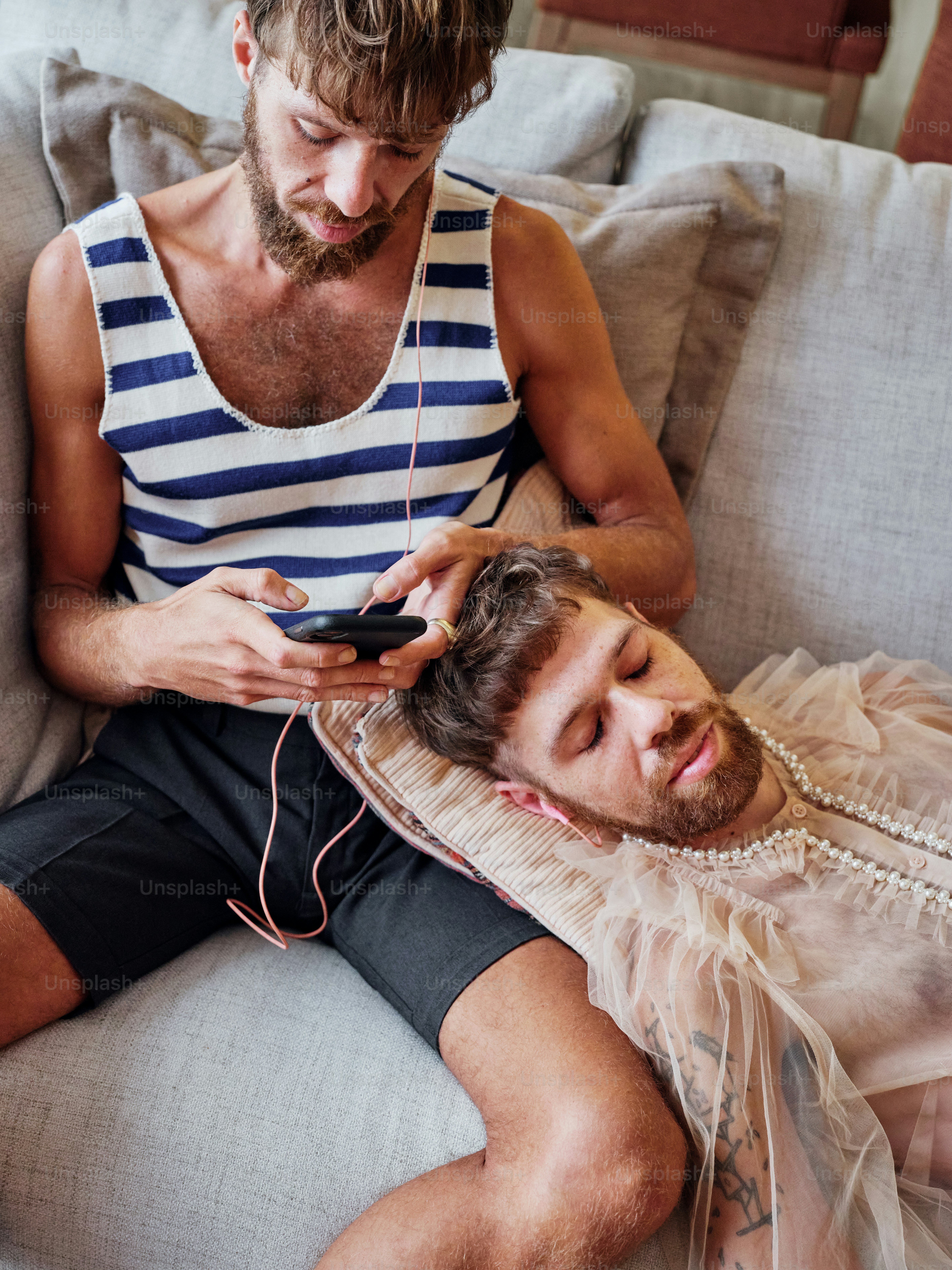 a man sitting next to another man on a couch