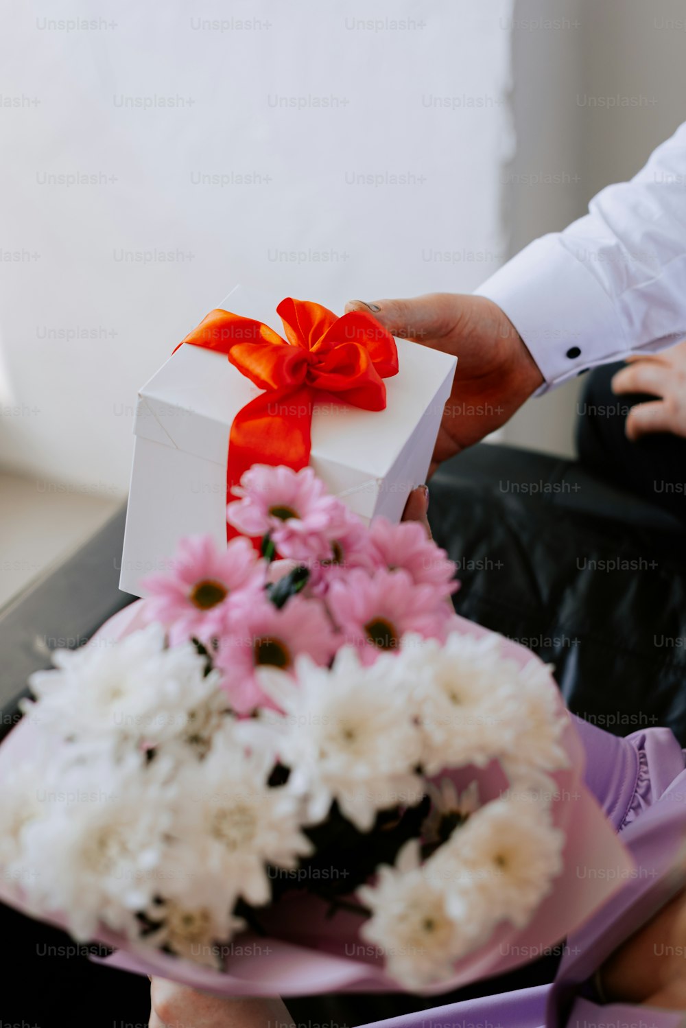 a person holding a gift box with flowers in it