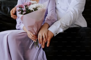 a man holding a bouquet of flowers next to a woman