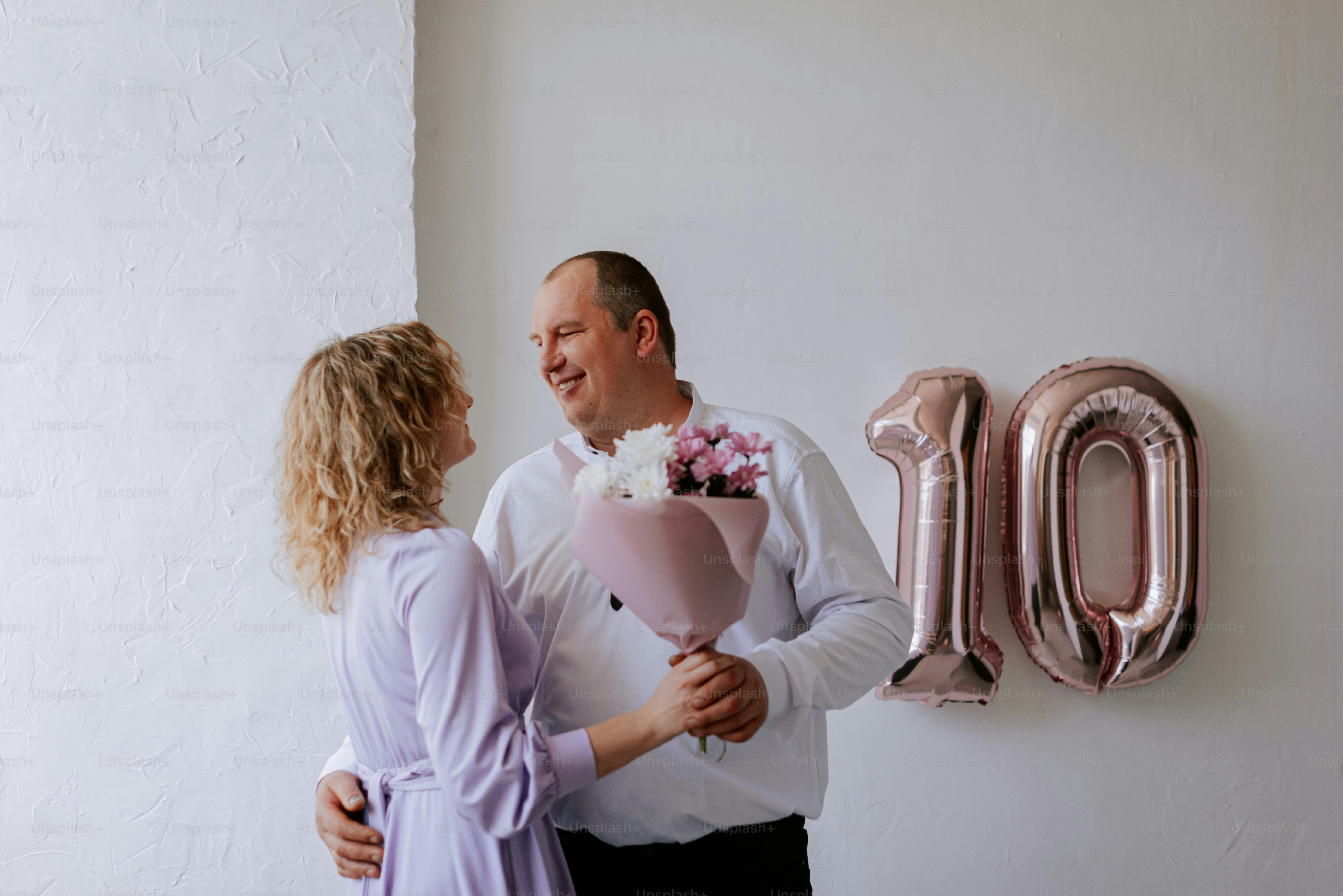 um homem segurando um buquê de flores ao lado de uma mulher