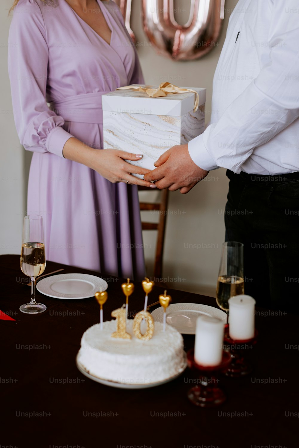 a man and a woman holding a box with a cake on it