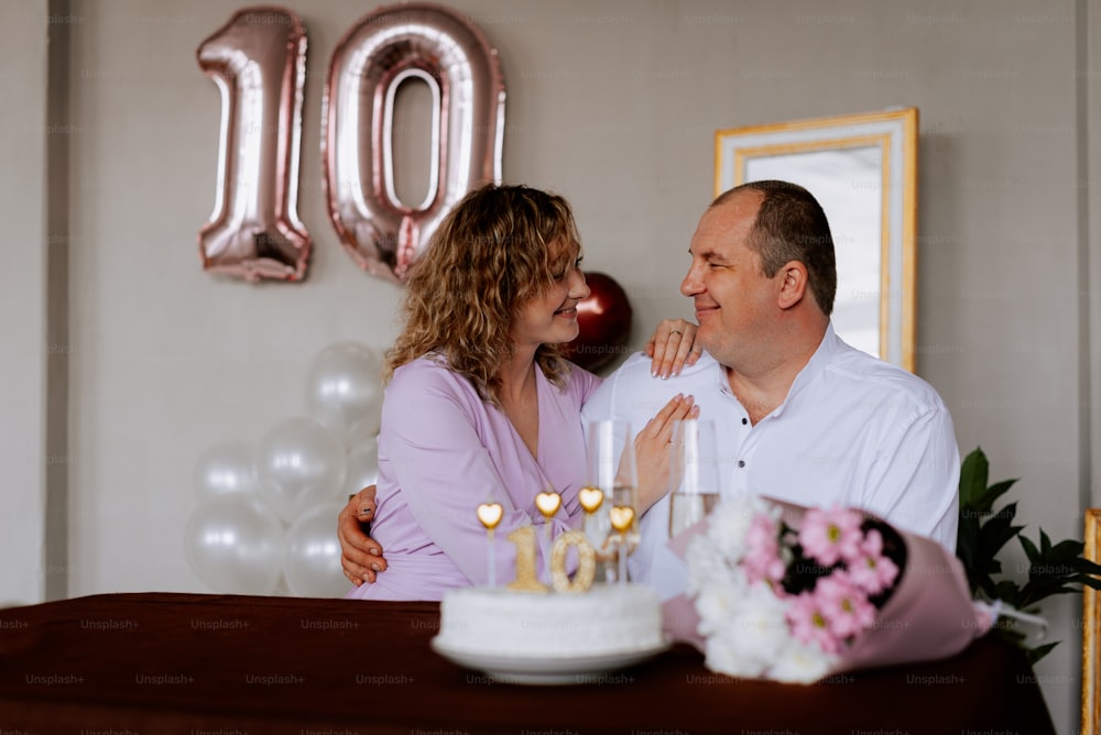 a man and a woman sitting at a table with a cake