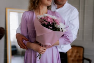 a man holding a bouquet of flowers next to a woman