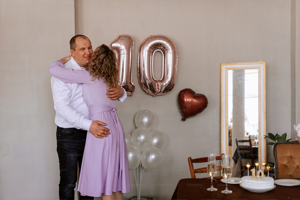 a man and a woman hugging in front of balloons