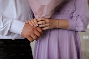 a close up of two people holding hands