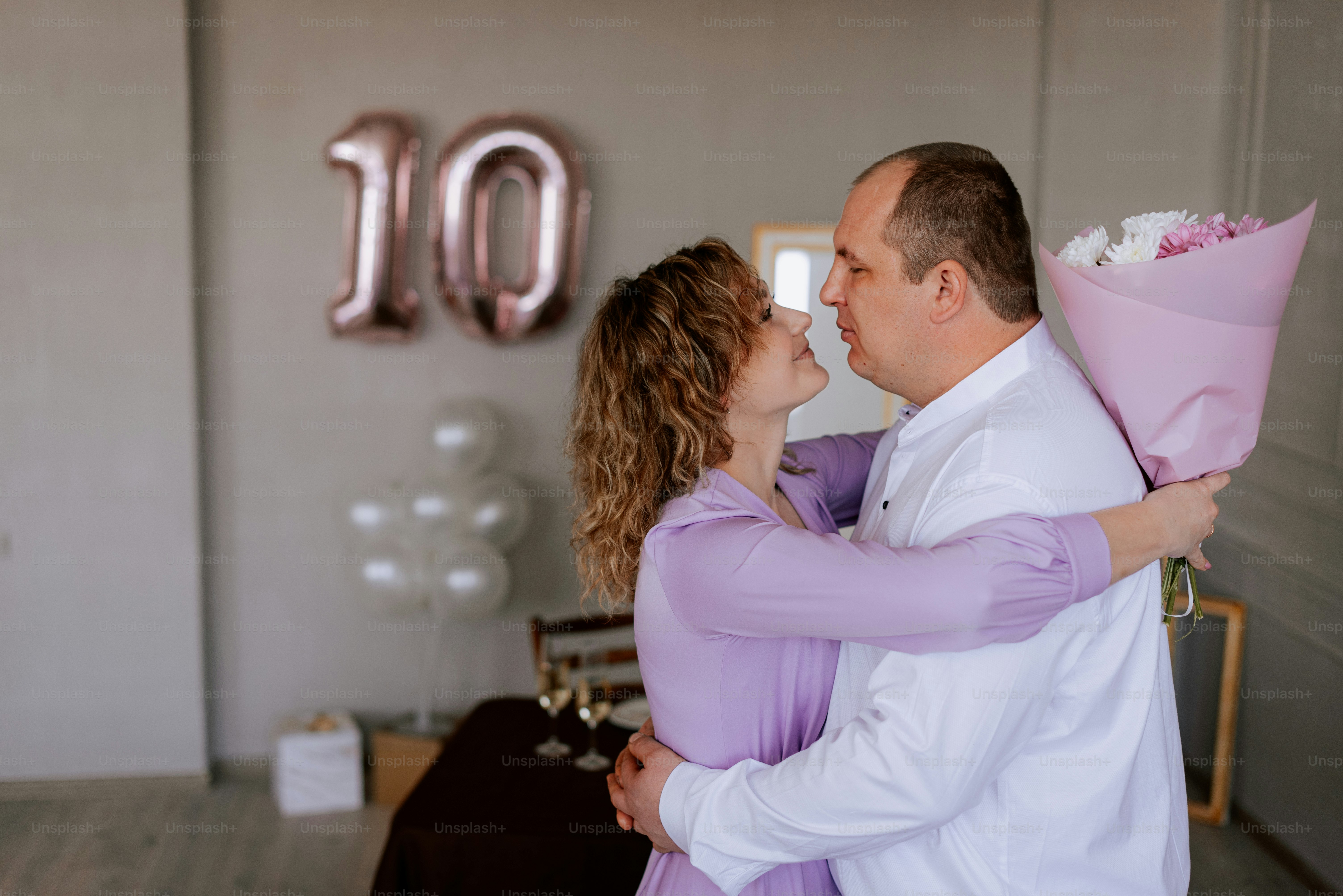 a man holding a bouquet of flowers and kissing a woman