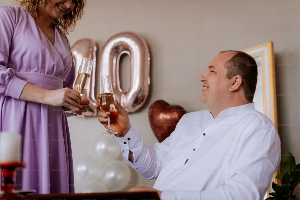 a man holding a glass of champagne next to a woman