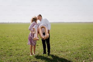 a man and a little girl standing in a field