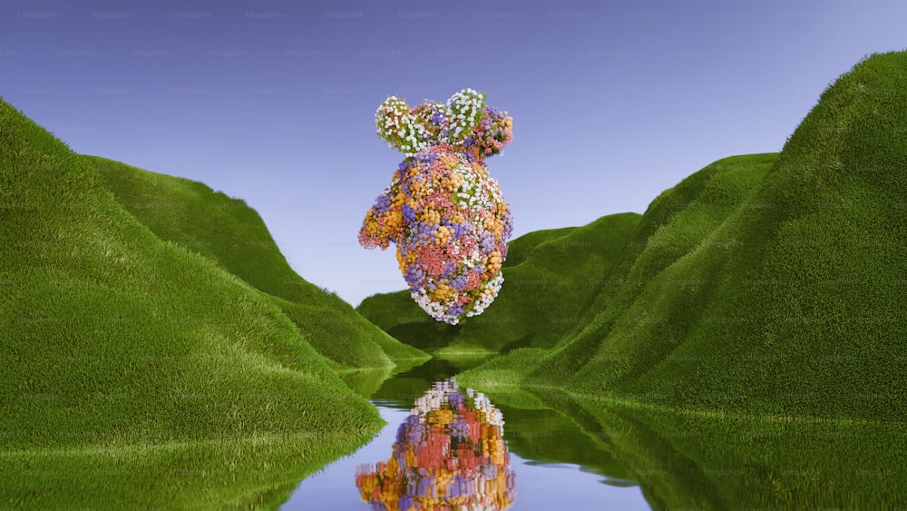 a teddy bear made out of flowers sitting on top of a lush green hillside