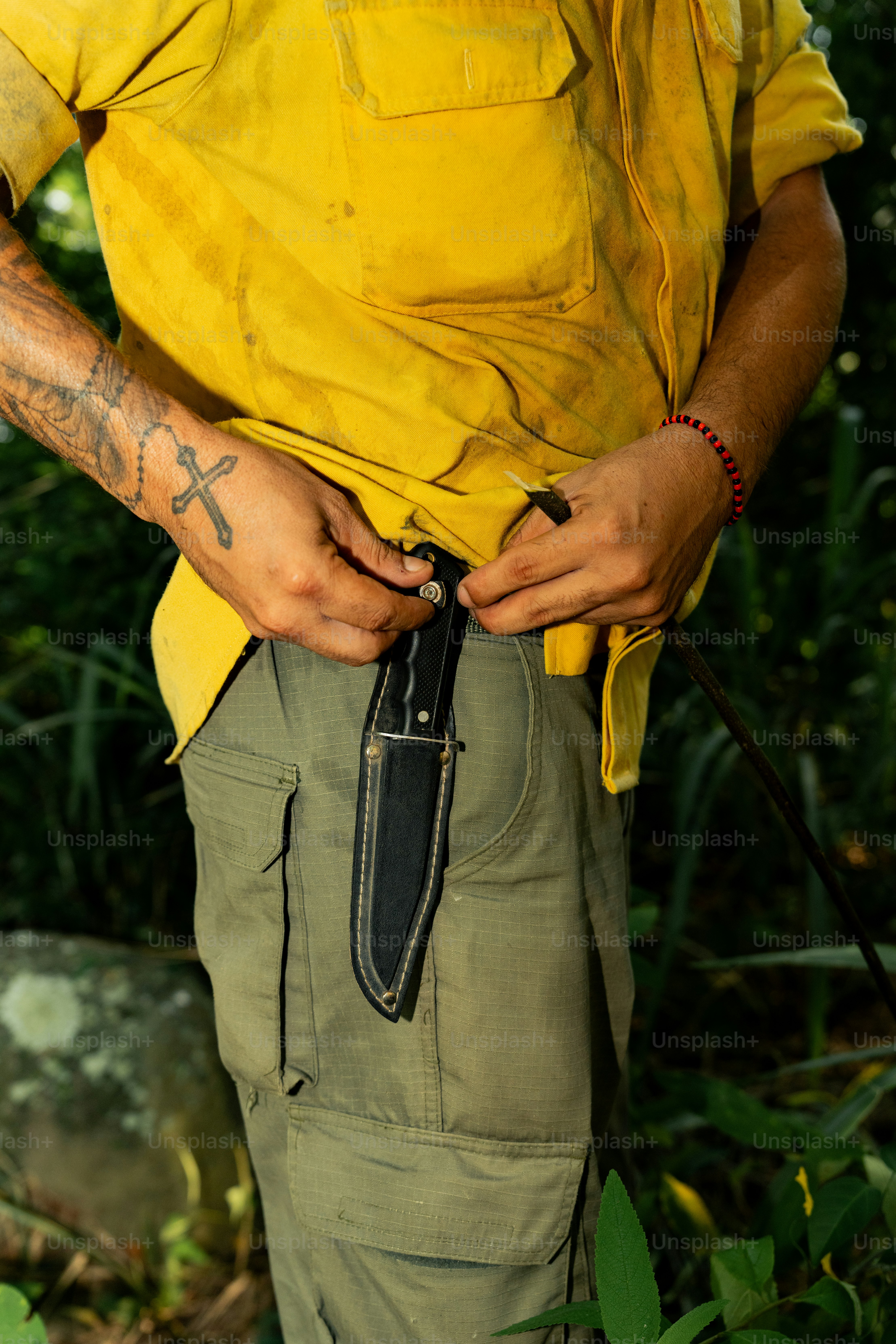 a man in a yellow shirt is holding a knife