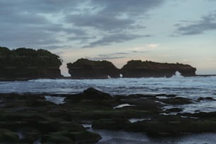 un paio di grandi rocce sedute in cima a una spiaggia
