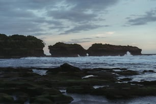 a couple of large rocks sitting on top of a beach