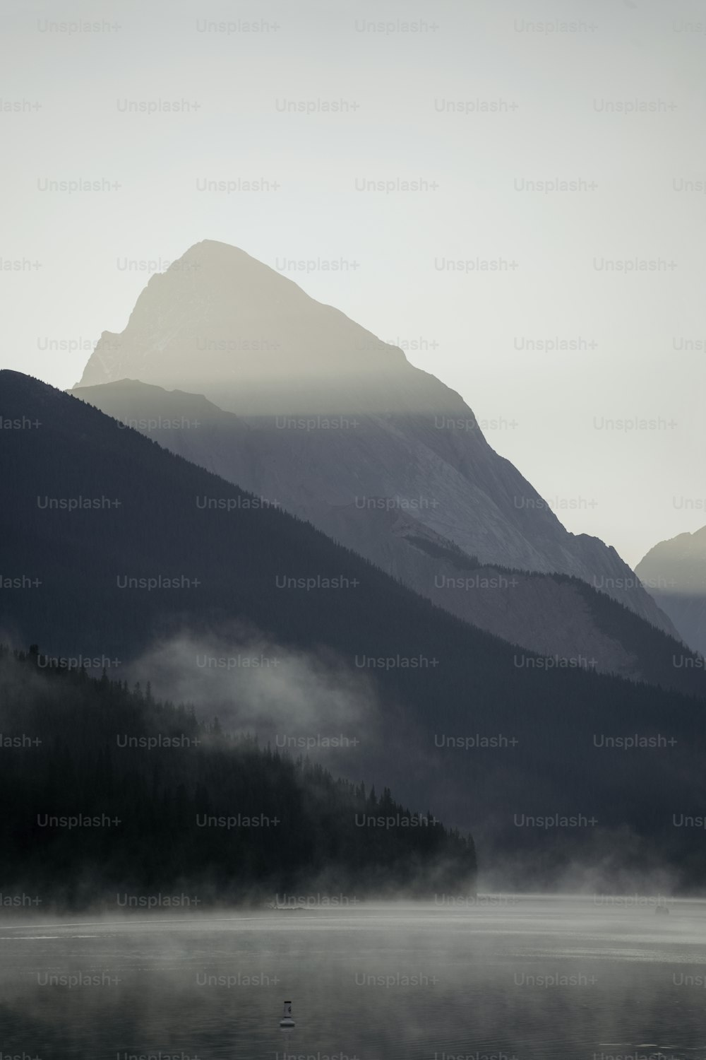 a boat floating on top of a lake surrounded by mountains