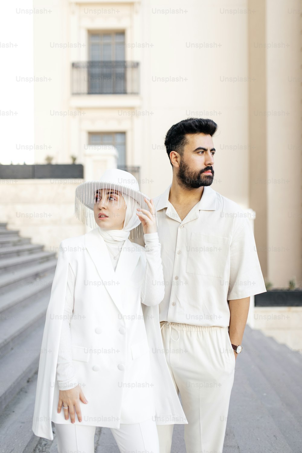 a man and a woman in white clothes standing next to each other