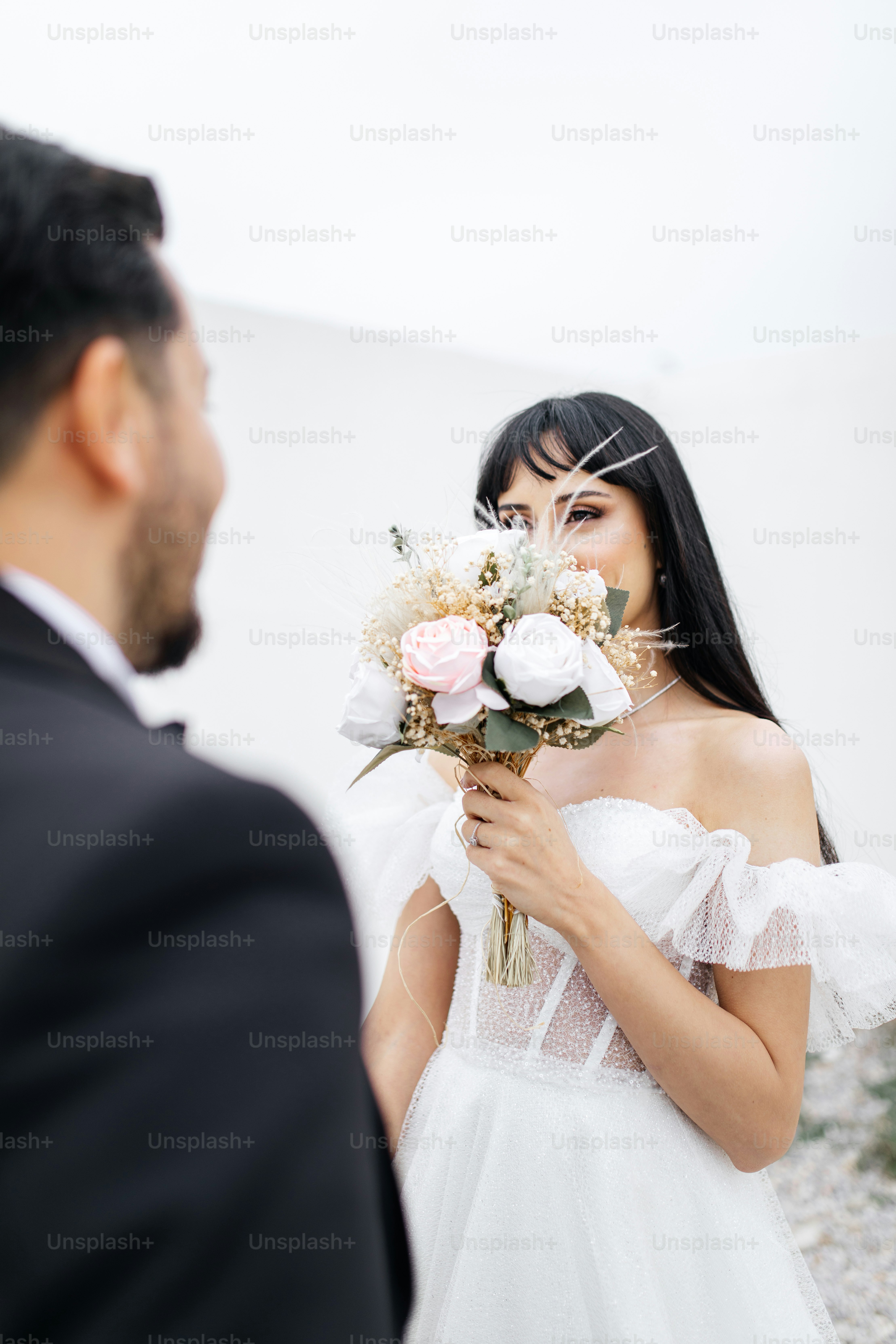A woman in a white dress holding a bouquet of flowers photo – Wedding ...
