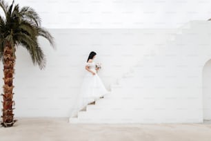 a woman in a wedding dress walking down a set of stairs