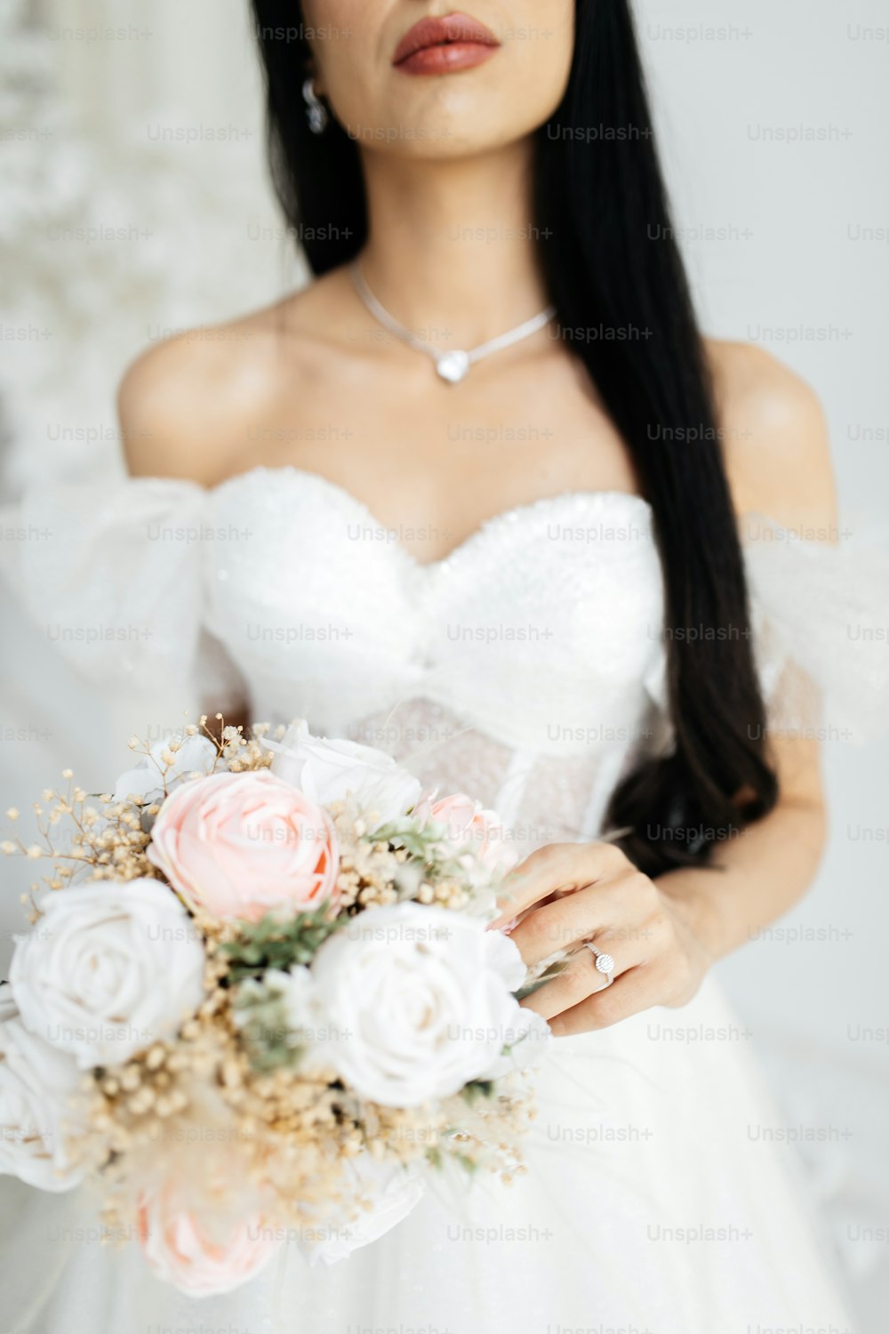 una mujer con un vestido de novia sosteniendo un ramo de flores