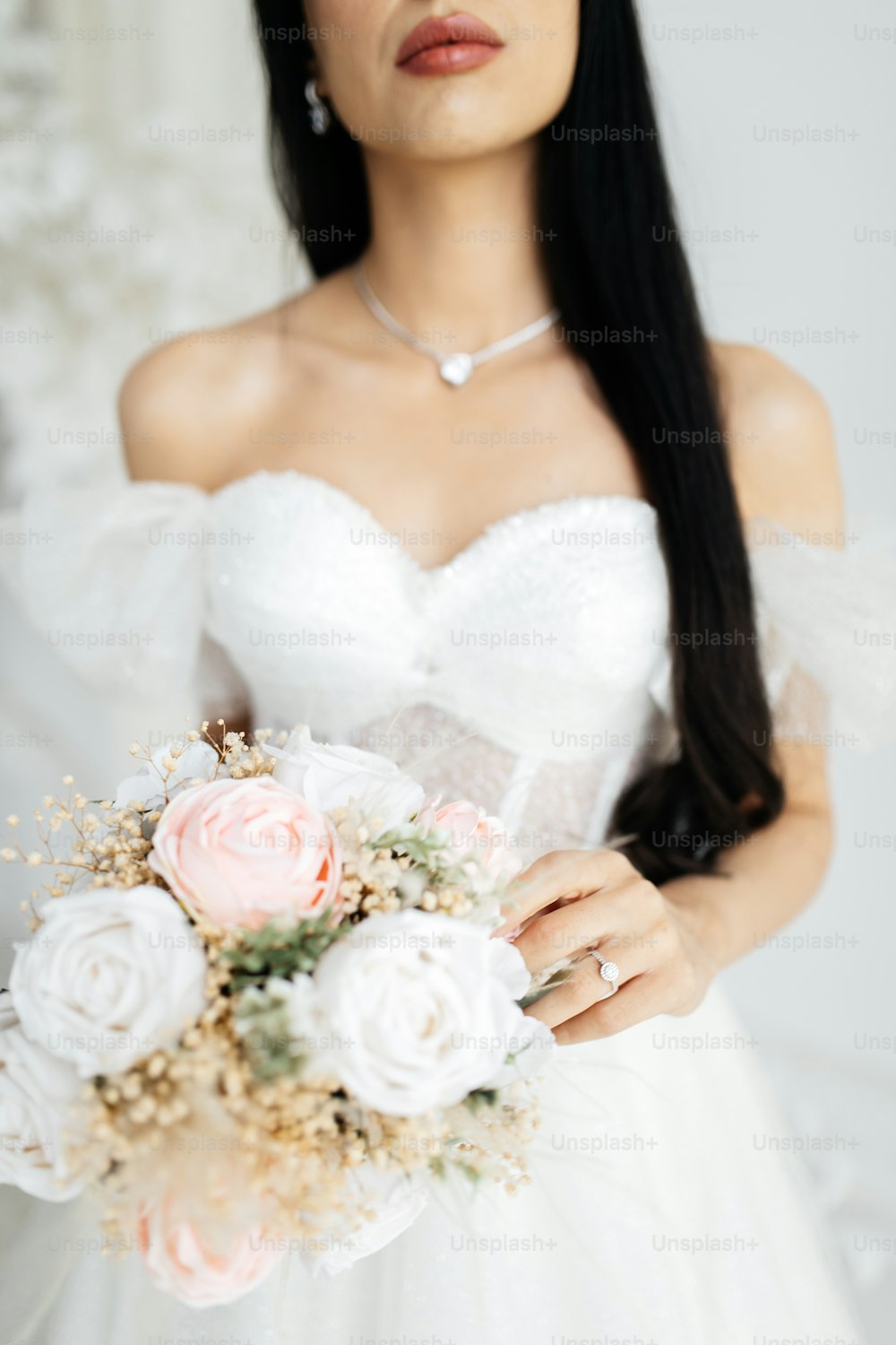 a woman in a wedding dress holding a bouquet of flowers