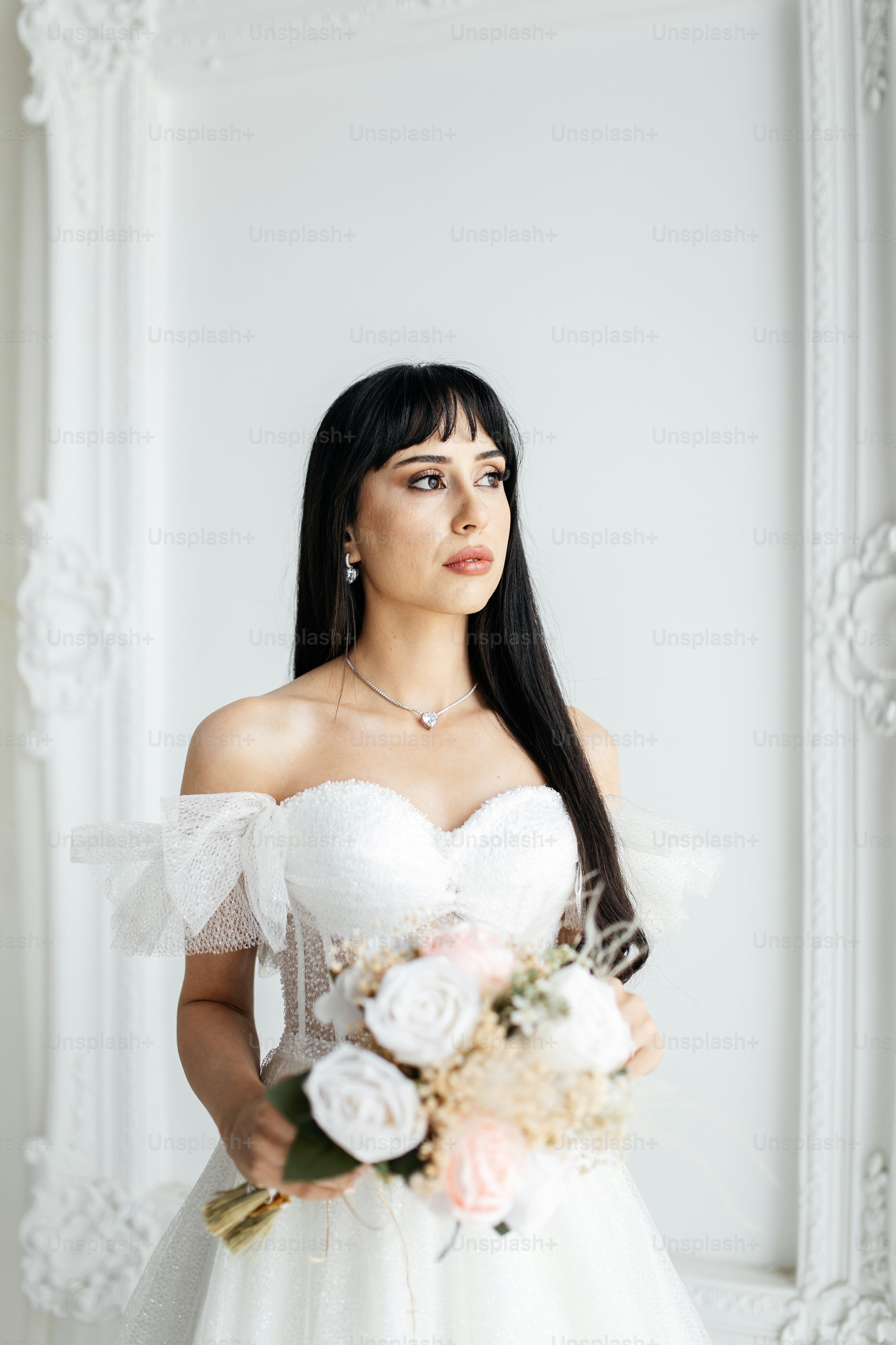 A woman in a wedding dress holding a bouquet of flowers photo – Wedding ...