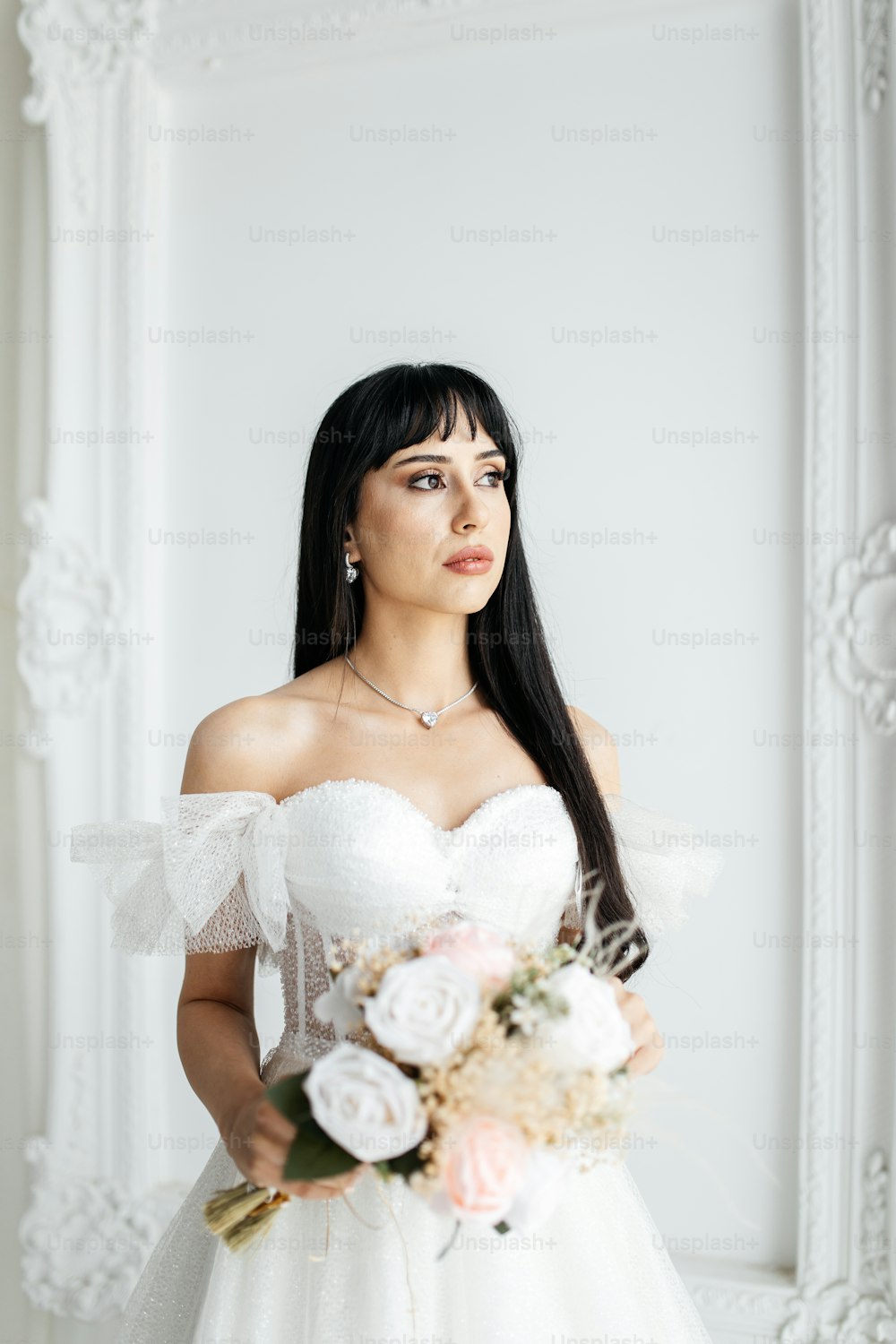 a woman in a wedding dress holding a bouquet of flowers