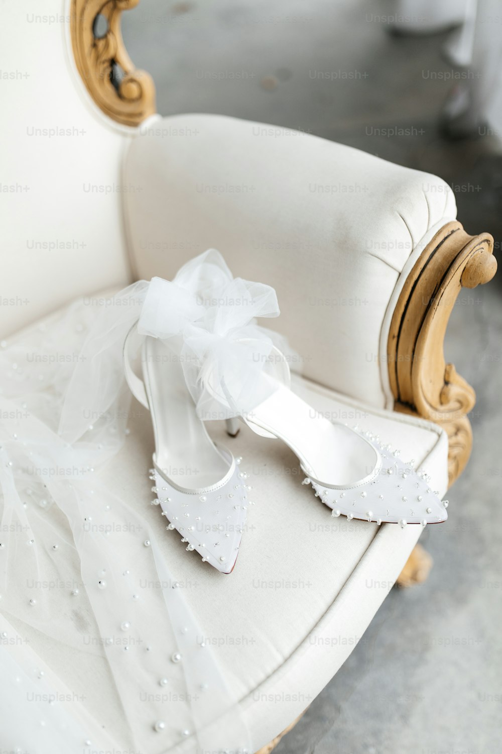 a pair of white shoes sitting on top of a white chair