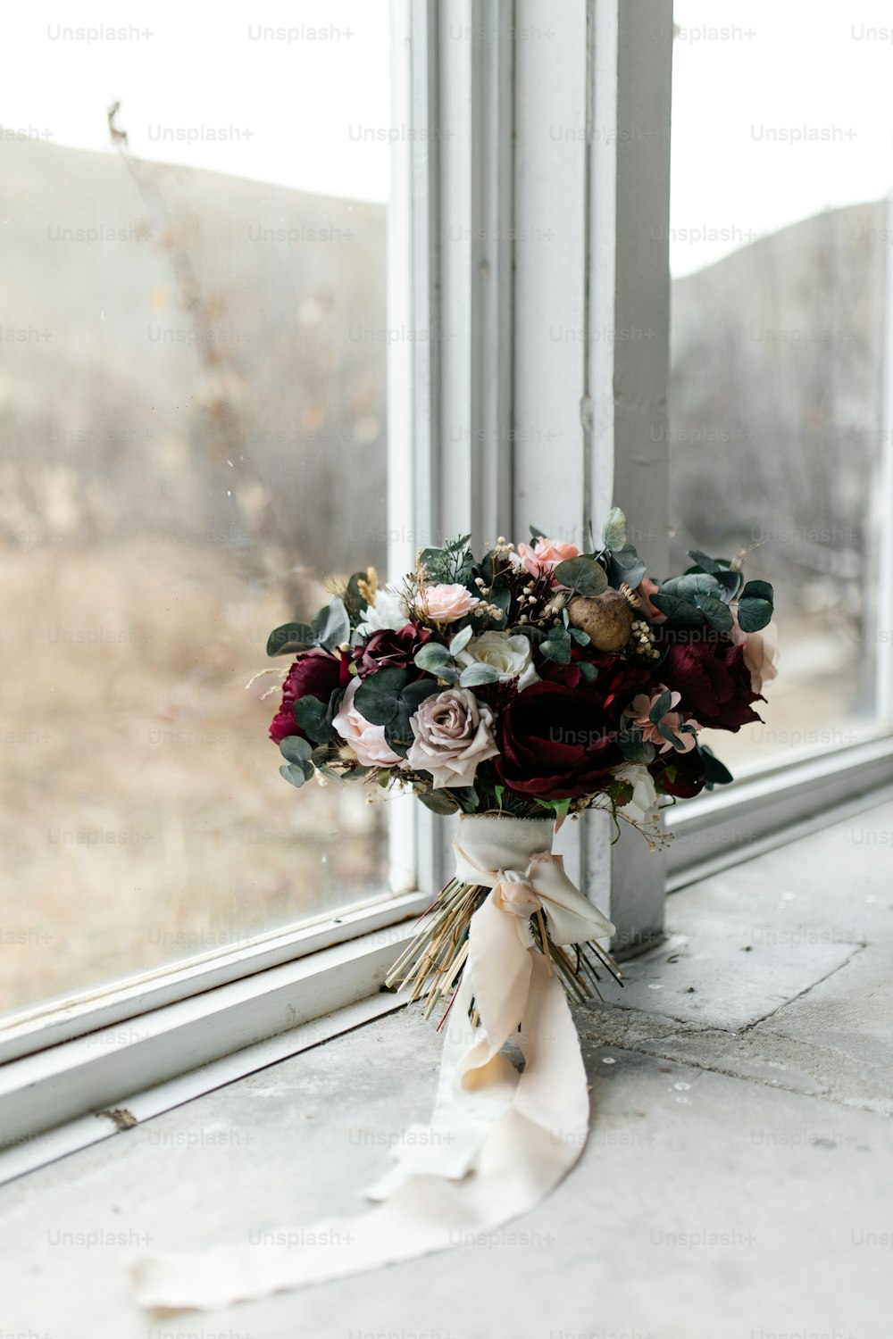 un bouquet de fleurs posé sur un rebord de fenêtre