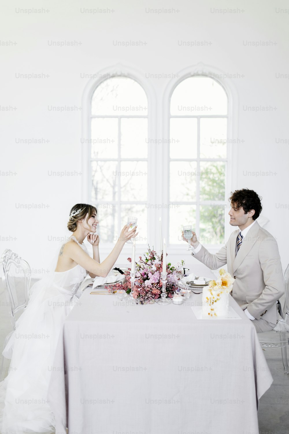 a bride and groom toasting at a table