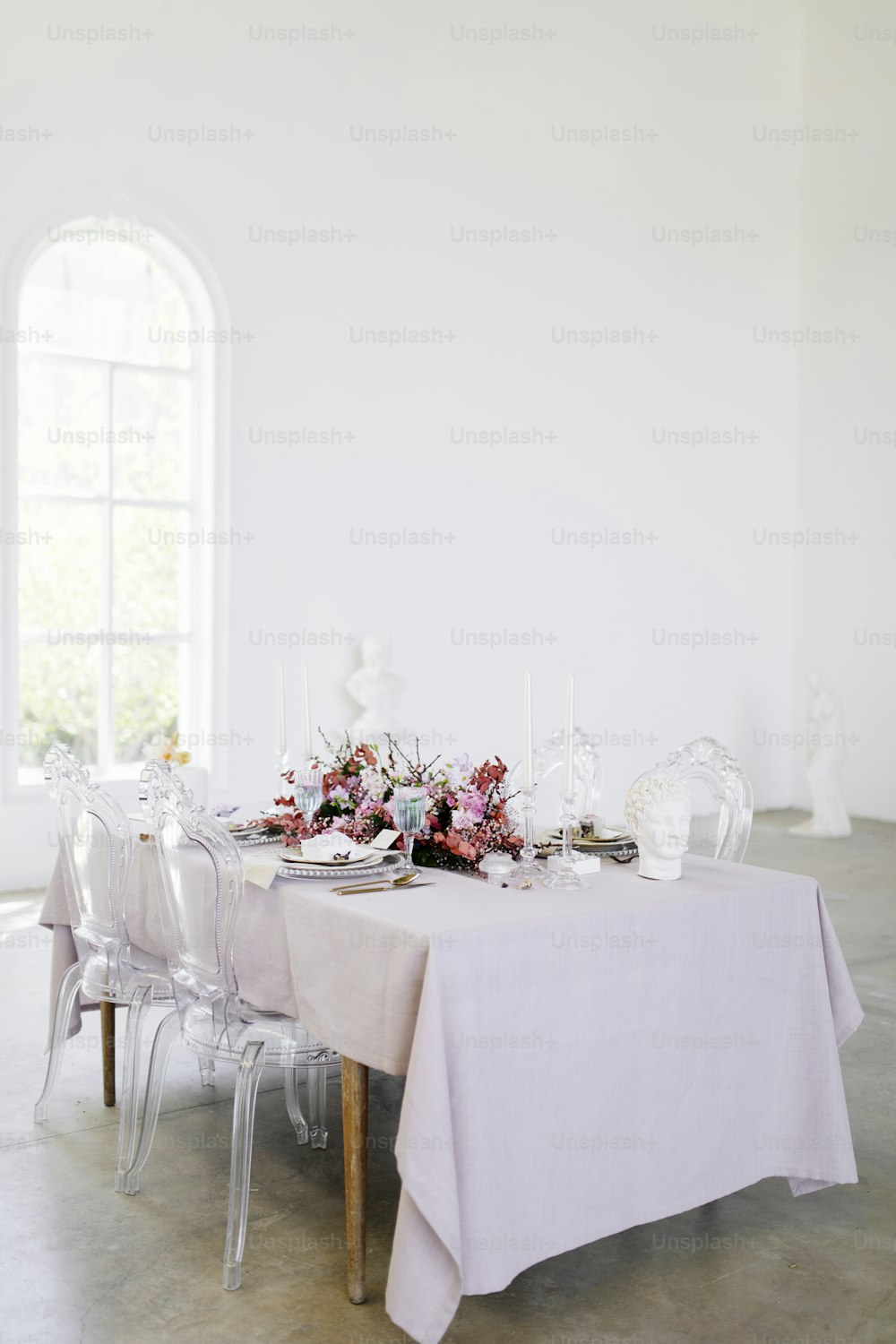 una mesa con un mantel blanco y flores sobre ella