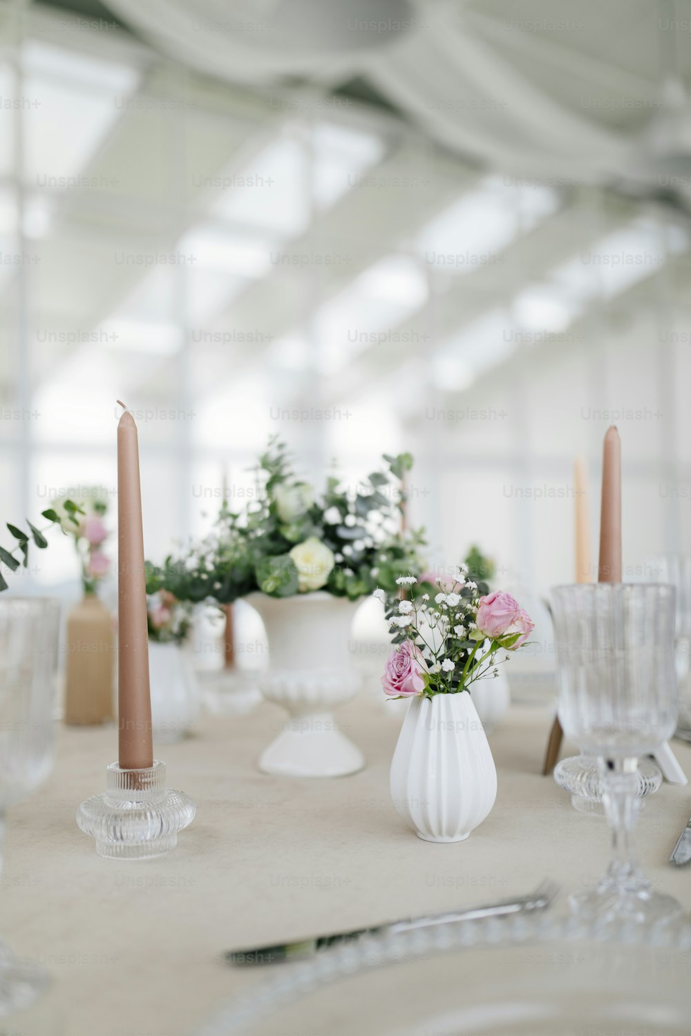 a table topped with white vases filled with flowers