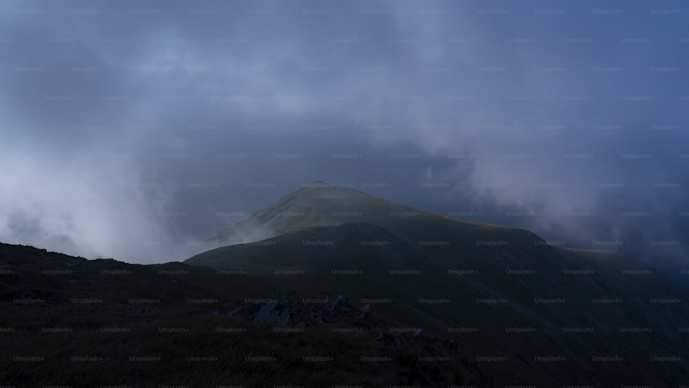 una montaña con un pico muy alto bajo un cielo nublado
