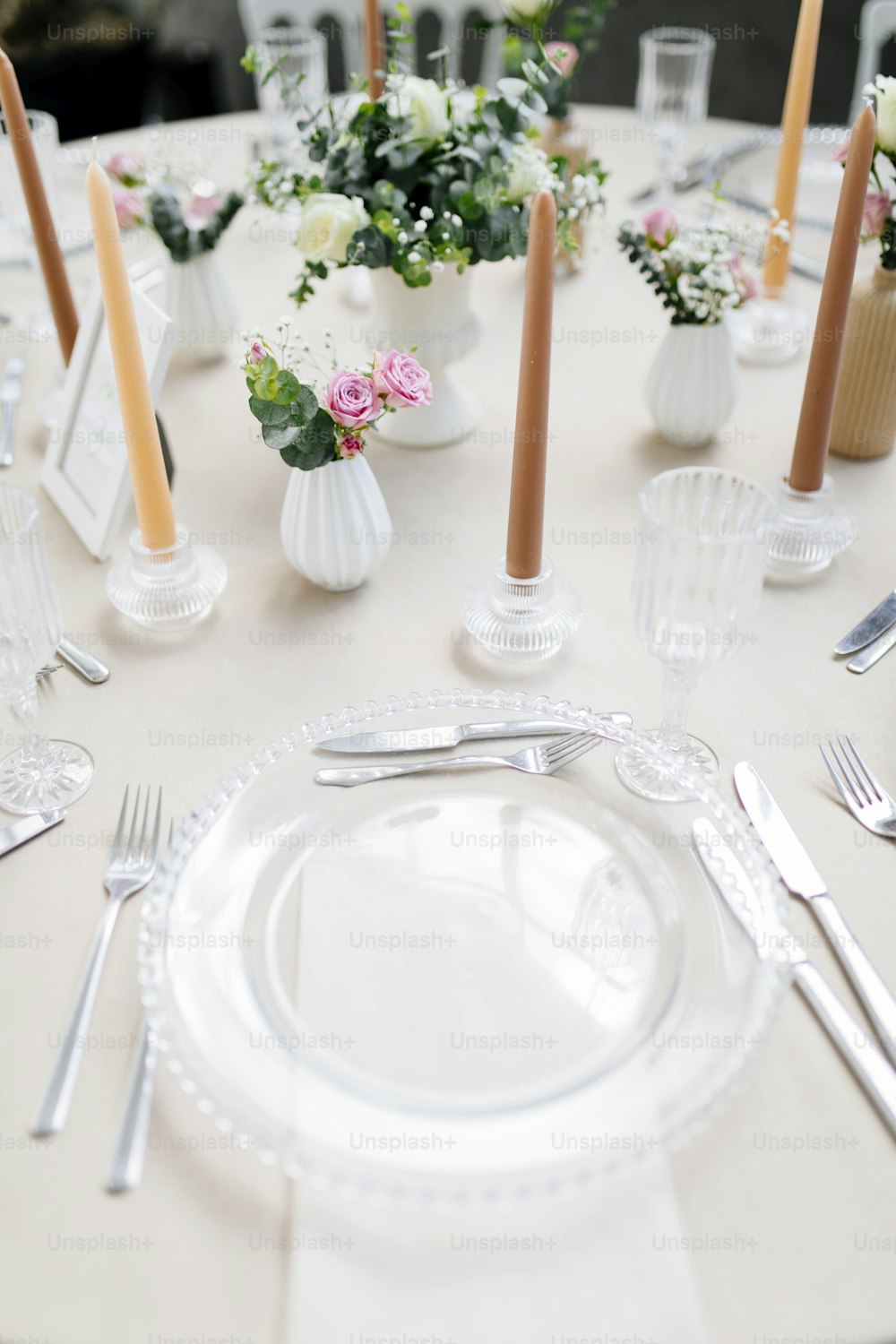 a table set with a white table cloth and silverware