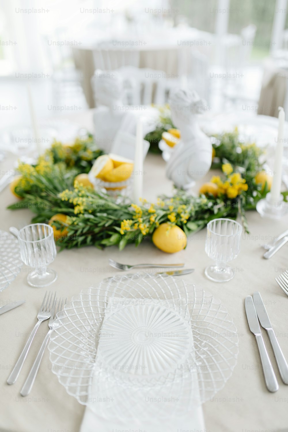 uma mesa com uma toalha de mesa branca e flores amarelas