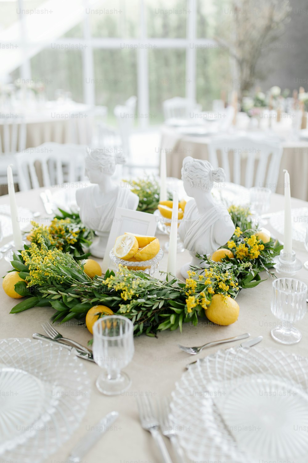 a table with lemons and greenery on it