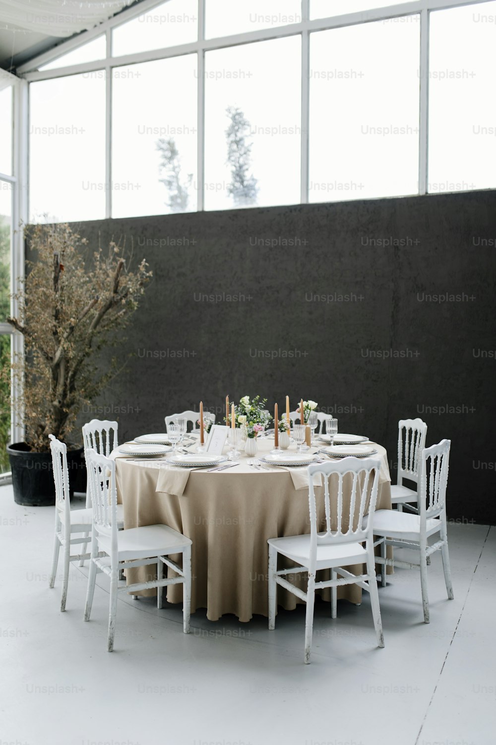 흰색 의자와 베이지색 식탁보가 있는 원형 테이블
