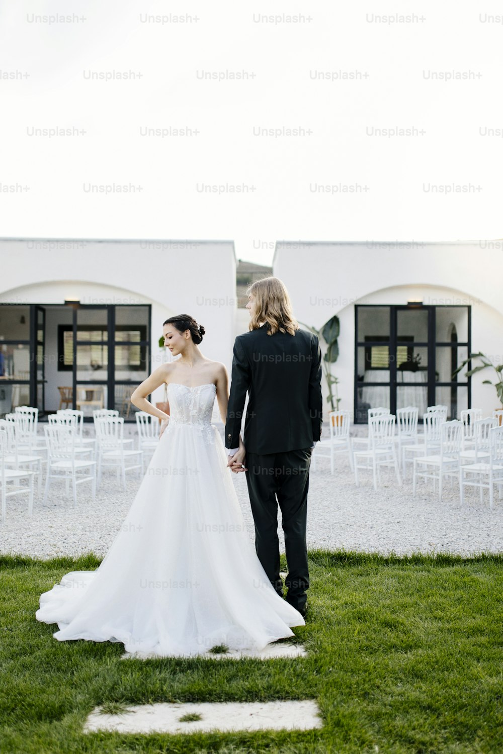 하얀 건물 앞에 서 있는 신랑 신부