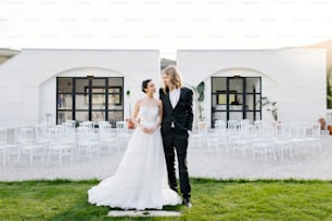 a bride and groom standing in front of a white building