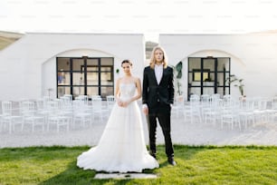 a bride and groom standing in front of a white building