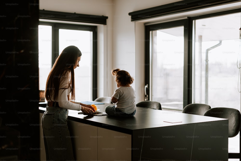Eine Frau und ein Kind sitzen an einer Küchentheke
