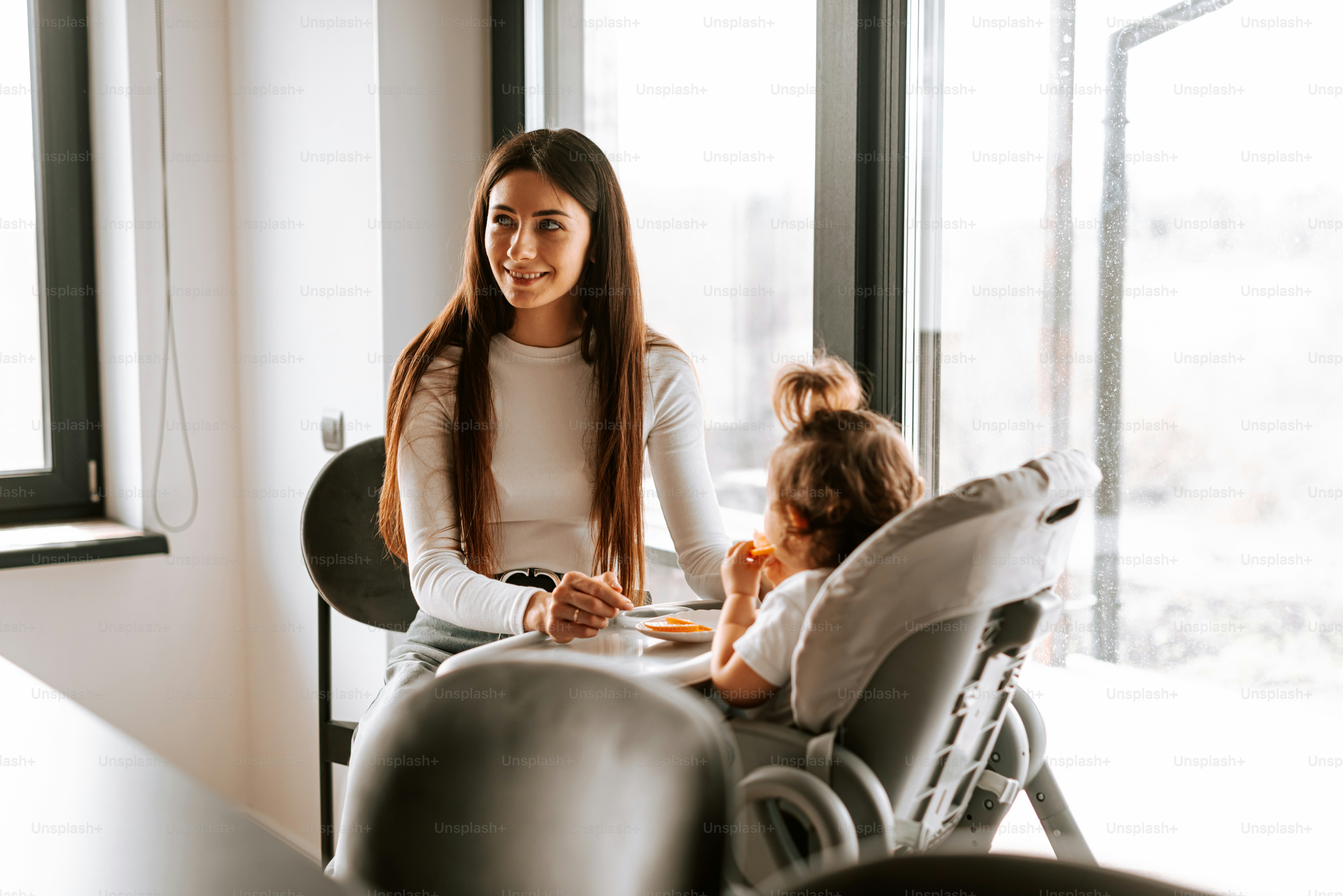 a woman sitting in a chair next to a little girl