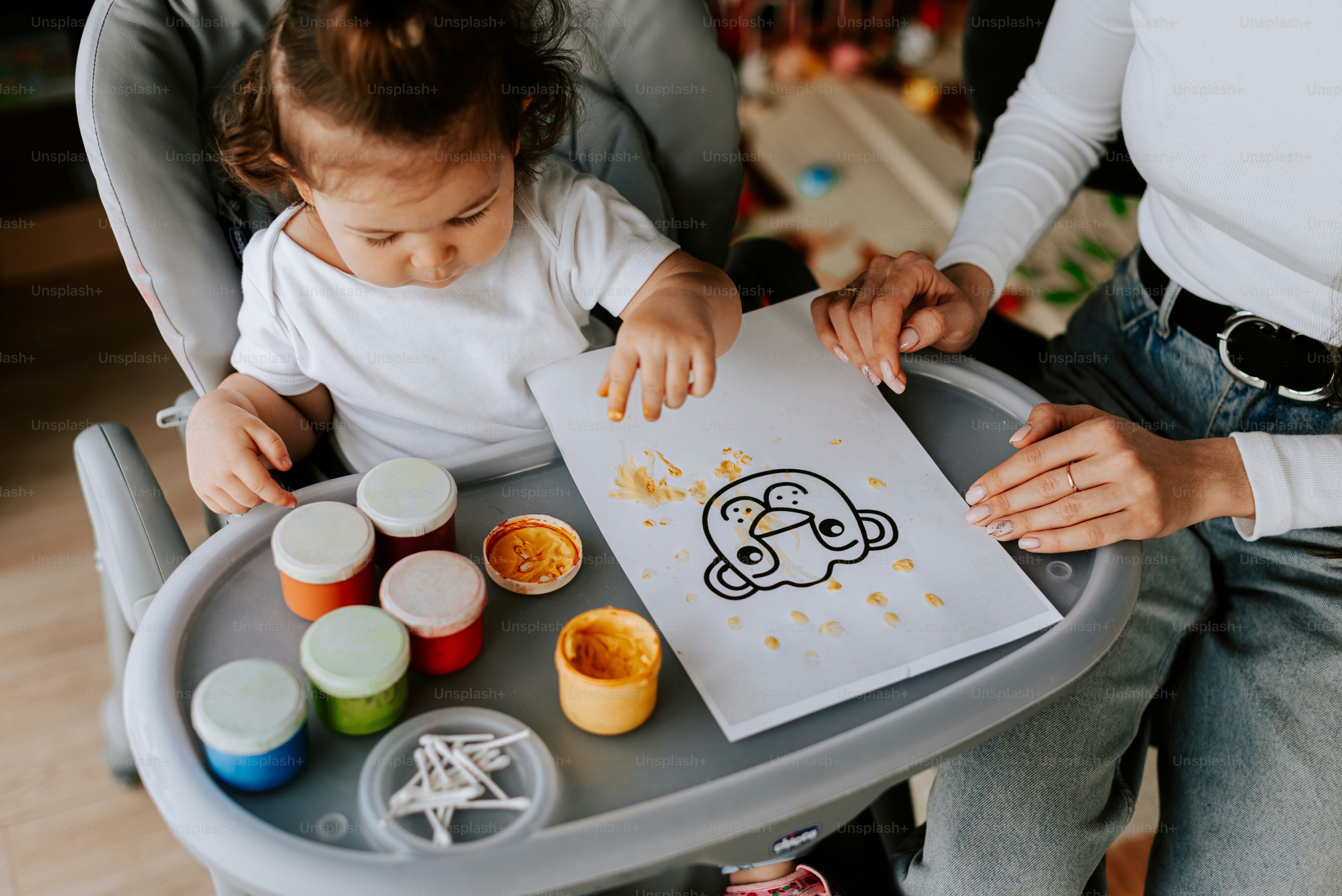 a woman holding a baby in a high chair